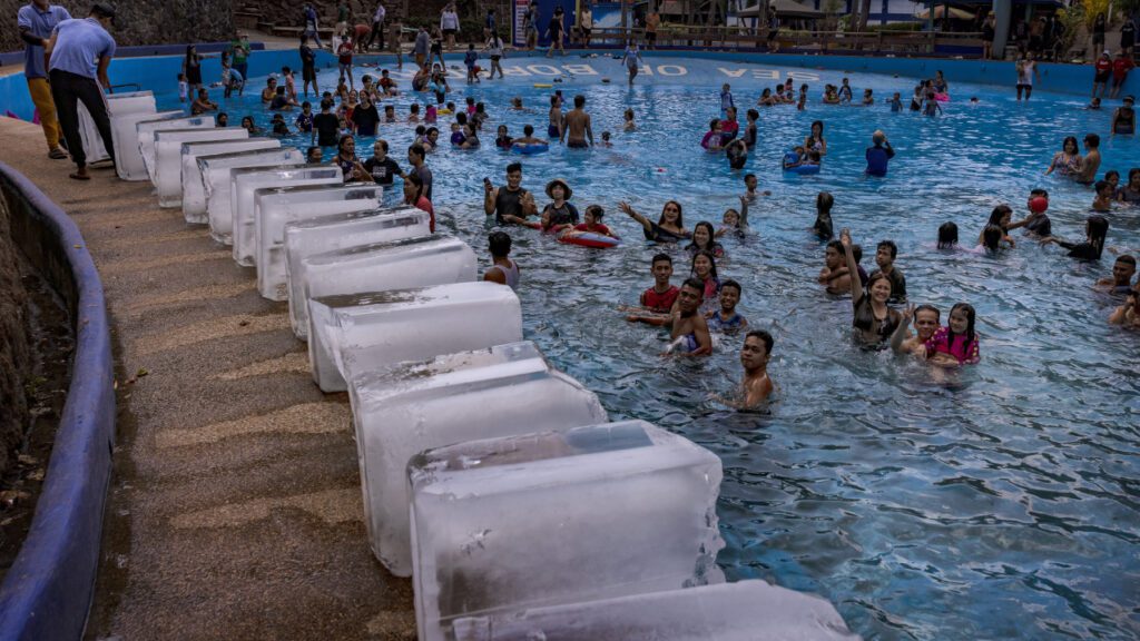 MARILAO, PHILIPPINES - MAY 04, 2024: Workers prepare to dump blocks of ice at a pool amid extreme heat in Marilao, Bulacan province.  Sweltering conditions strained power grids, sparked health warnings, and left residents desperate for ways to stay cool. May 2024 was the world's warmest May on record.