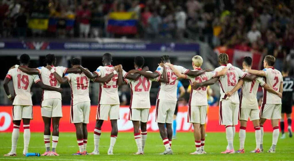 Canada players link arms before a shootout during a Copa America quarterfinal soccer match between Venezuela and Canada, Friday, July 5, 2024, in Arlington, Texas.