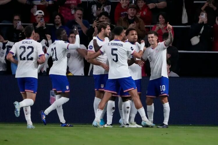 Christian Pulisic (right) is congratulated by teammates after scoring one of his goals in Monday's game.