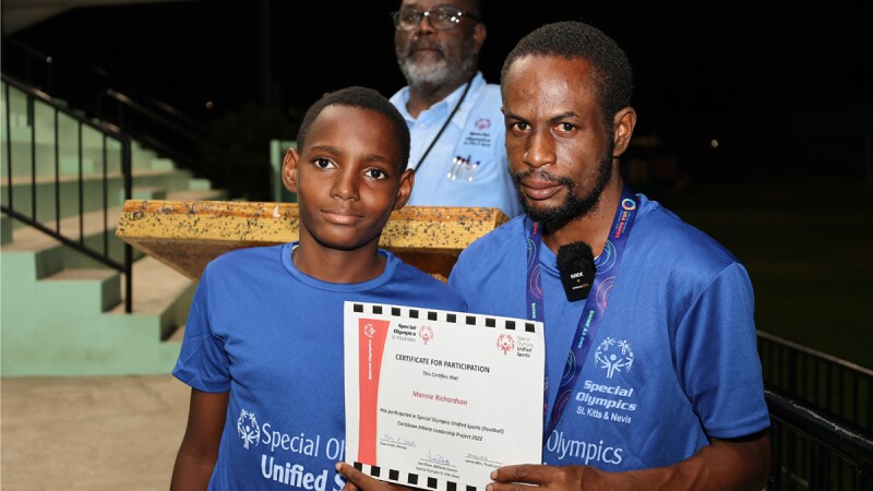 Man presenting award to a young man. 