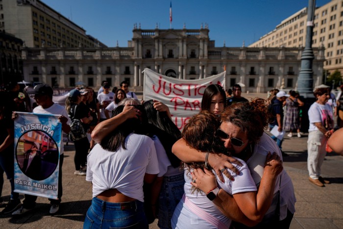 Relatives and friends of Mayra Castillo, a 13-year-old victim of violence, hug during a protest against criminal violence outside La Moneda government palace in Santiago