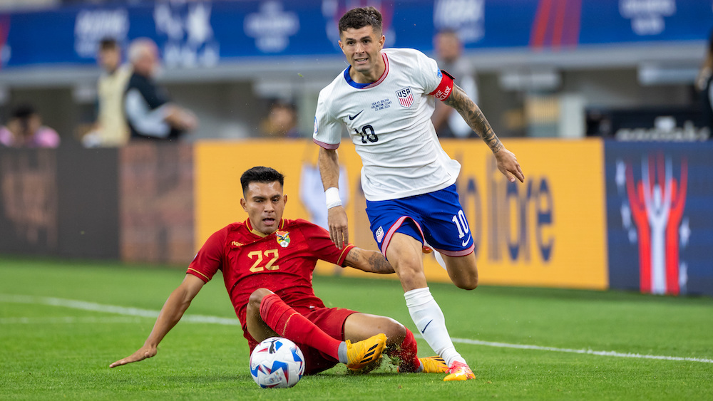 ARLINGTON, TX - JUNE 23: United States forward Christian Pulisic (#10) dribbles around Bolivia midfielder Hector Cuellar (#22) during the CONMEBOL Copa America match between the United States and Boliva on June 23, 2024 at AT&T Stadium in Arlington, TX. (Photo by  Matthew Visinsky/Icon Sportswire via Getty Images)