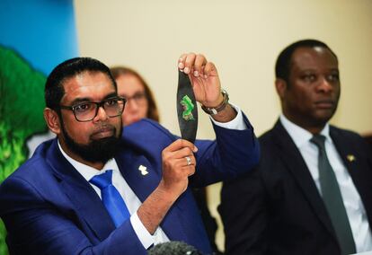 Guyanese President Mohamed Irfaan Ali displays a bracelet with a map of Guyana while addressing the media in Kingstown, St. Vincent and the Grenadines, December 14, 2023. 