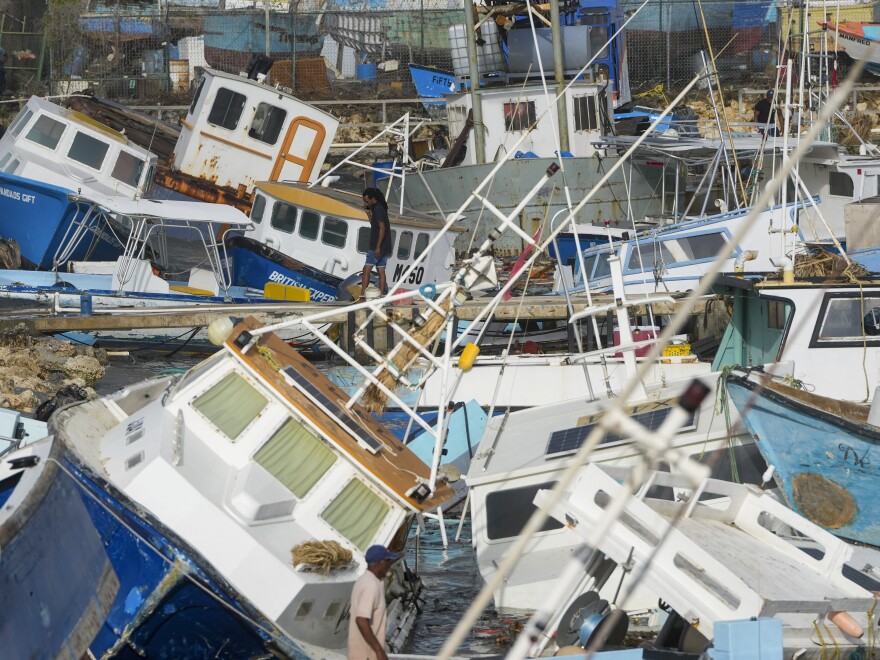 A fisherman looks at fishing vessels damaged by Hurricane Beryl at the Bridgetown Fisheries in Barbados, Monday, July 1, 2024. 