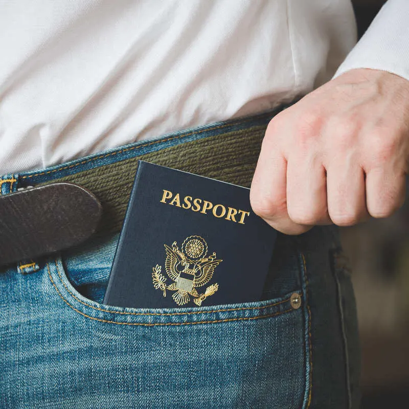 Close Up Of A US Passport On The Front Pocket Of A Male American Traveler As He Reaches Out For It, International Travel