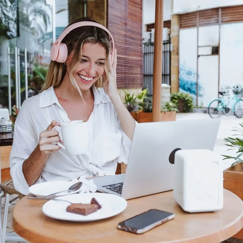 Young Happy Female Digital Nomad Working From A Cafe As She Smiles, Unspecified Location