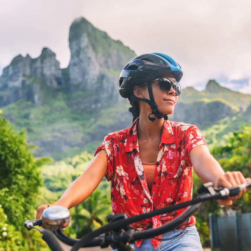 Young Female Traveler Bicycling Through Forest In Costa Rica, Central America