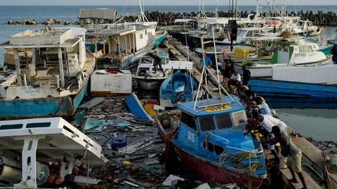 Fishermen push a boat damaged by Hurricane Beryl at the Bridgetown fisheries, Barbados, Tuesday, July 2, 2024. (AP Photo/Ricardo Mazalan)