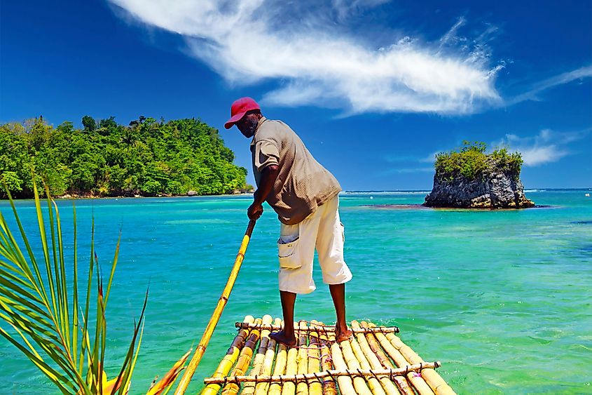 Port Antonio (San San Beach), Jamaica. A man stands on a bamboo raft in a secluded lagoon. Source: Shutterstock/Ralf Liebhold