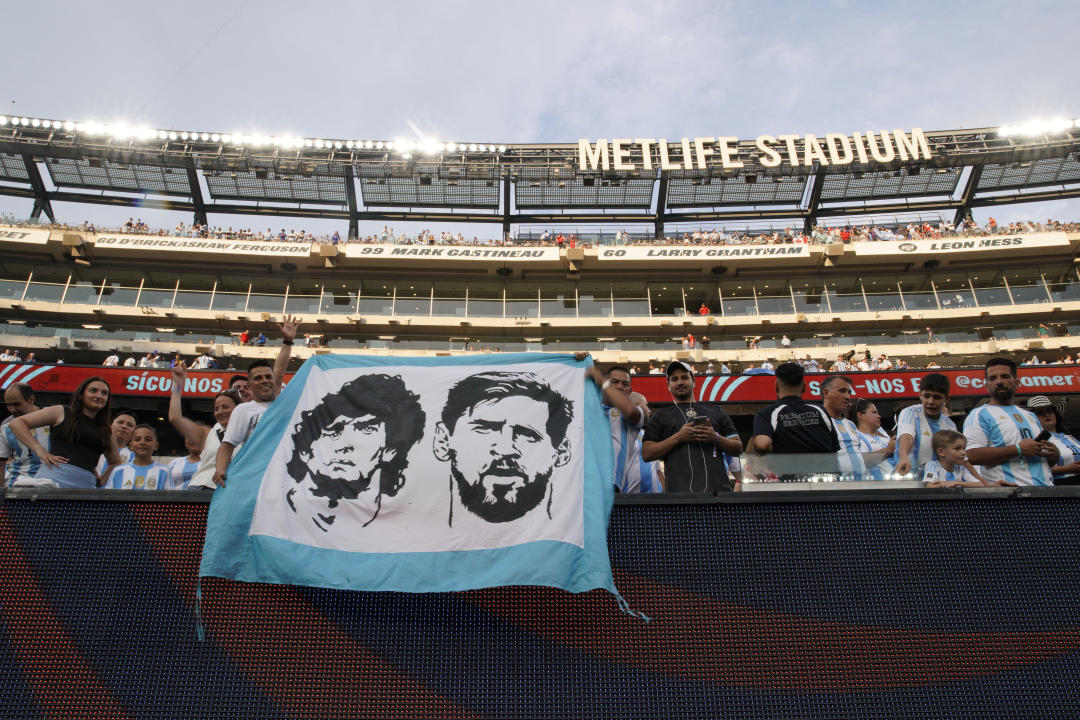 Argentina fans hold a banner with images of Argentina's forward Lionel Messi (R) and late Argentine football player Diego Maradona during the Conmebol 2024 Copa America tournament semi-final football match between Argentina and Canada at MetLife Stadium, in East Rutherford, New Jersey on July 9, 2024. (Photo by EDUARDO MUNOZ / AFP) (Photo by EDUARDO MUNOZ/AFP via Getty Images)