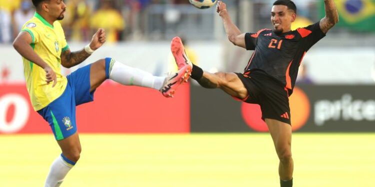 Brazil's Lucas Paqueta and Colombia's Daniel Munoz fight for a ball