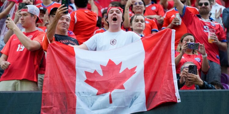 A soccer fan holds a Canadian flag prior to a Copa America Group A soccer match against Chile, in Orlando, Fla., Saturday, June 29, 2024. (John Raoux / AP Photo)