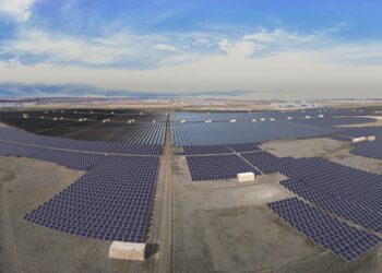 Rows of solar panels and a bright blue sky.