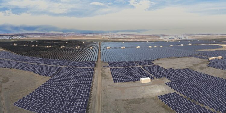 Rows of solar panels and a bright blue sky.