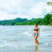 Female Tourist Walking Into The Ocean In Costa Rica, Central America
