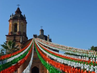 an old building and streamers showing a mexican flag