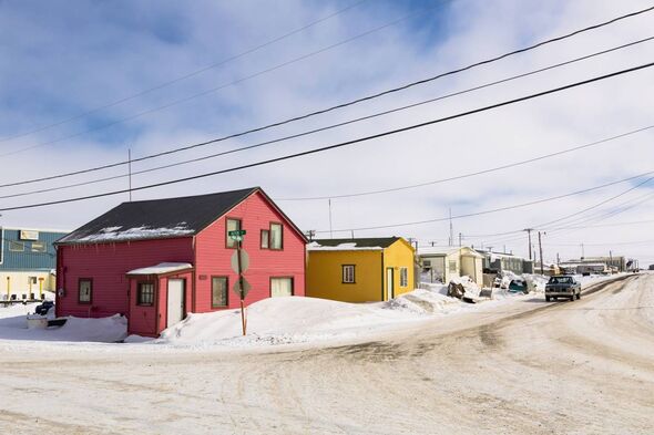 Brightly painted houses with snow drifts against them