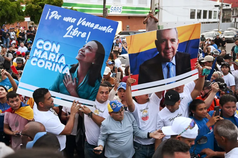 Supporters of Venezuelan opposition presidential candidate Edmundo González Urrutia and opposition leader María Corina Machado hold posters during a campaign rally in Maracaibo, Venezuela, on July 23.