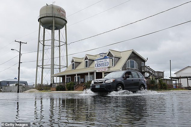 A motorist navigates a flooded intersection after heavy rains in Crisfield, Maryland, one of the states most threatened by coastal flooding