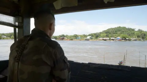 A legionnaire on look-out duty looks out from French Guiana towards Brazil