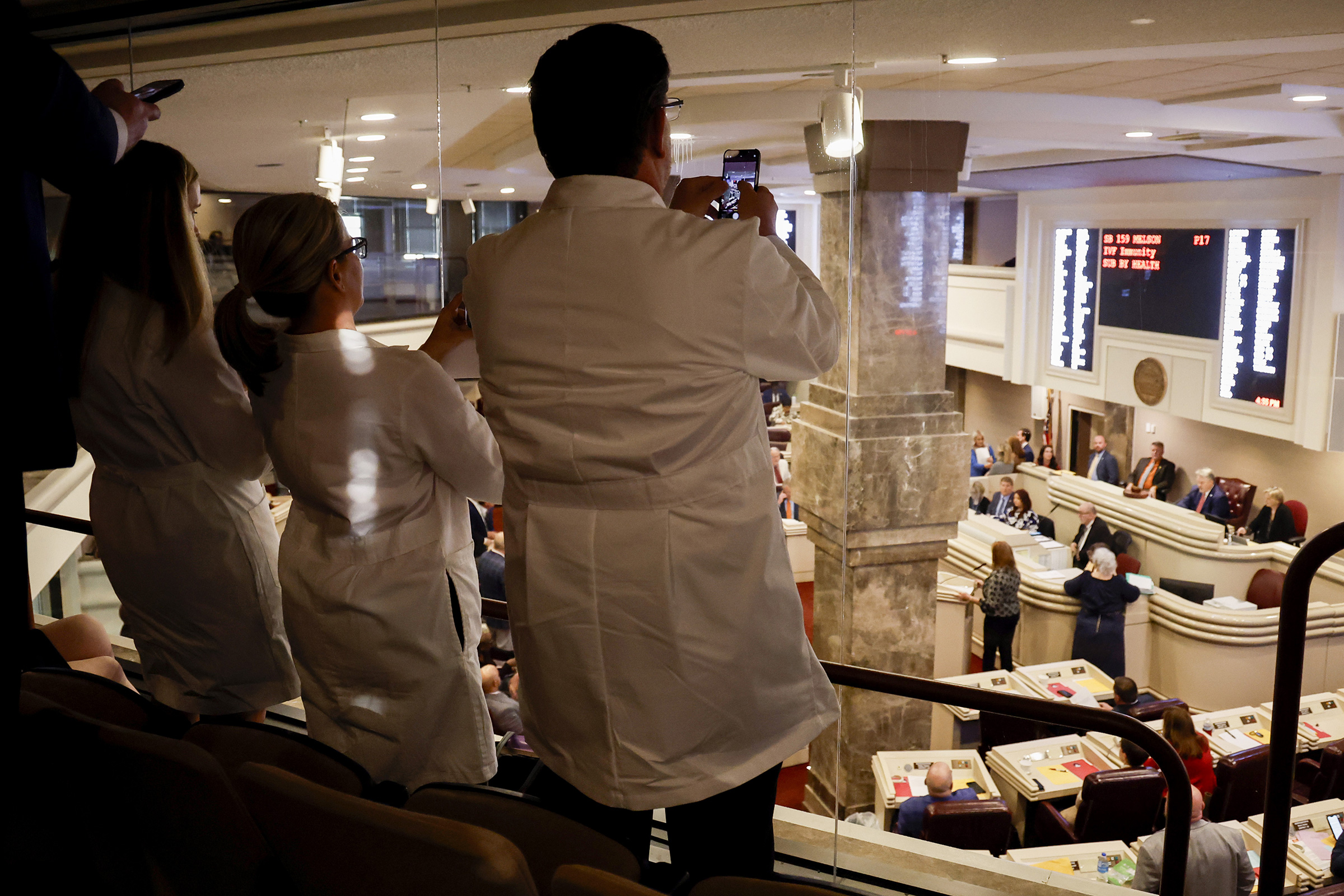 Doctors from the Alabama Fertility Clinic takes photos of the votes as the debate over SB159 bill (IVF Fertility Bill) in the House Chambers is voted on, in Montgomery, Ala., March 6, 2024.