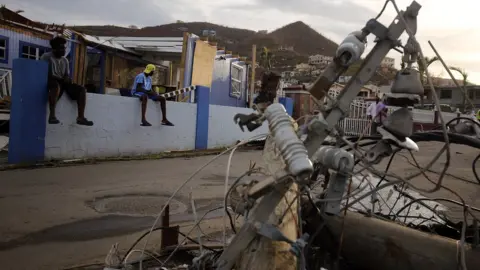 Paul Blake/BBC Residents look at downed power lines on British Virgin Islands