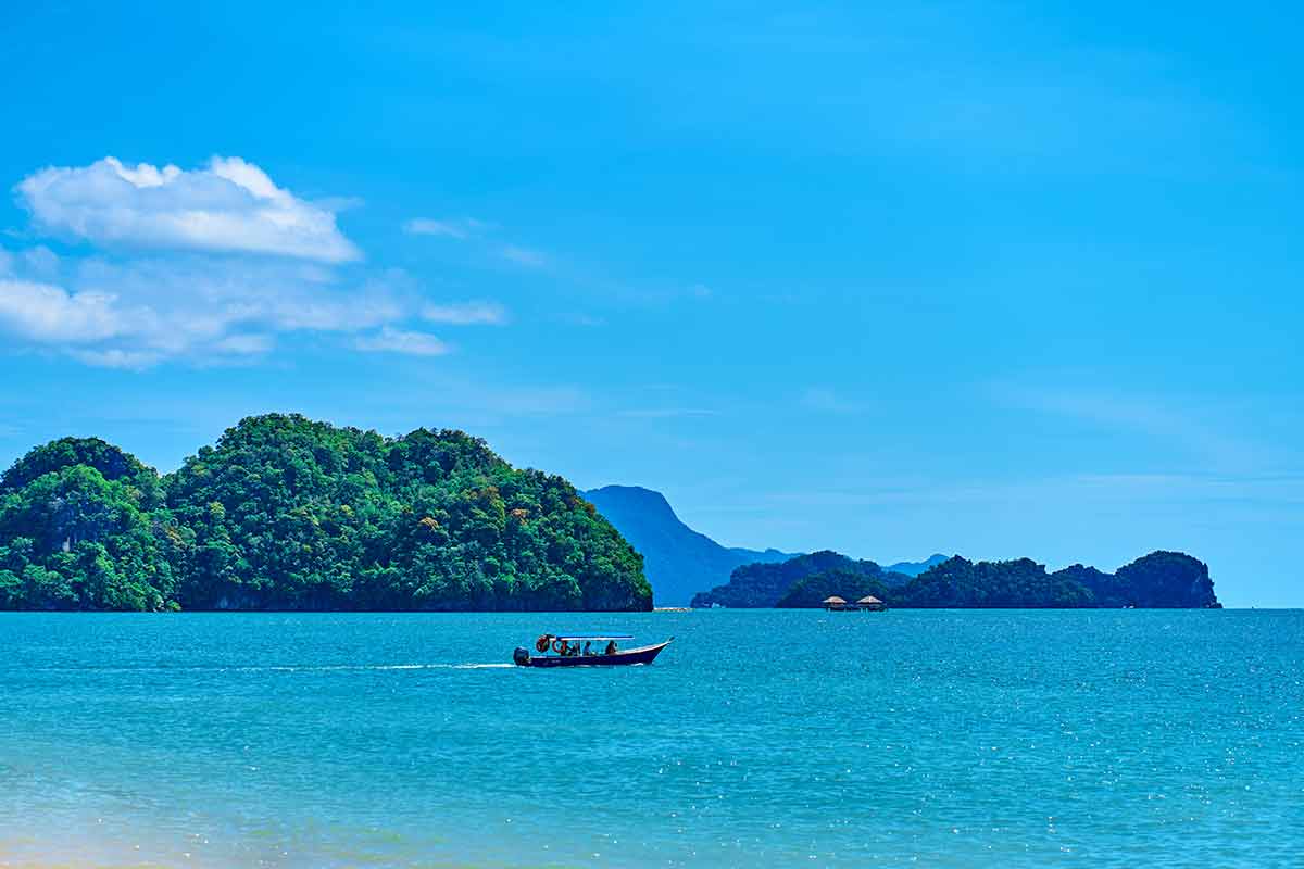 too many beaches in malaysia a sampan on the ocean cruising past lush jungle