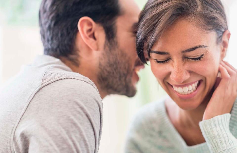 Couple whispering together indoors