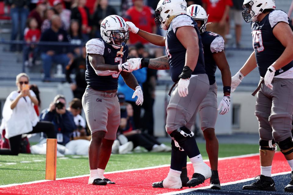 Nov 18, 2023; Tucson, Arizona, USA; Arizona Wildcats running back Jonah Coleman (3) celebrates with offensive lineman Jonah Savaiinaea (71) after a touchdown against the Utah Utes during the second half at Arizona Stadium. Mandatory Credit: Zachary BonDurant-USA TODAY Sports