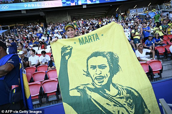 A Brazil fan holds a banner depicting Brazil's forward #10 Marta in the women's gold medal final football match between Brazil and US during the Paris 2024 Olympic Games at the Parc des Princes in Paris on August 10, 2024. (Photo by Jonathan NACKSTRAND / AFP) (Photo by JONATHAN NACKSTRAND/AFP via Getty Images)