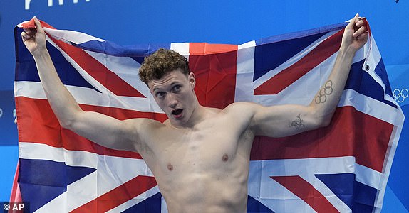 Bronze medalist Britain's Noah Williams holds the Union Jack after the men's 10m platform diving final, at the 2024 Summer Olympics, Saturday, Aug. 10, 2024, in Saint-Denis, France. (AP Photo/Lee Jin-man)