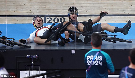 Paris 2024 Olympics - Track Cycling - Men's Madison, Final - Saint-Quentin-en-Yvelines Velodrome, Montigny-le-Bretonneux, France - August 10, 2024. Aaron Gate of New Zealand and Theo Reinhardt of Germany react after crashing during the race. REUTERS/Agustin Marcarian