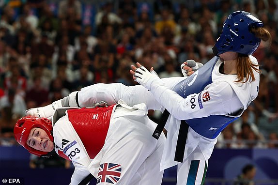 epa11542760 Svetlana Osipova of Uzbekistan (blue) and Rebecca McGowan of Britain (red) in action during their Women +67kg Quarterfinal of the Taekwondo competitions in the Paris 2024 Olympic Games, at the Grand Palais in Paris, France, 10 August 2024.  EPA/DIVYAKANT SOLANKI