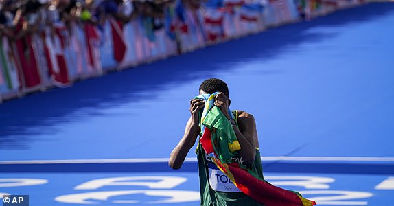 Ethiopia's Tamirat Tola celebrates after crossing the finish line to win the gold medal at the end of the men's marathon competition at the 2024 Summer Olympics, Saturday, Aug. 10, 2024, in Paris, France. (AP Photo/Vadim Ghirda)