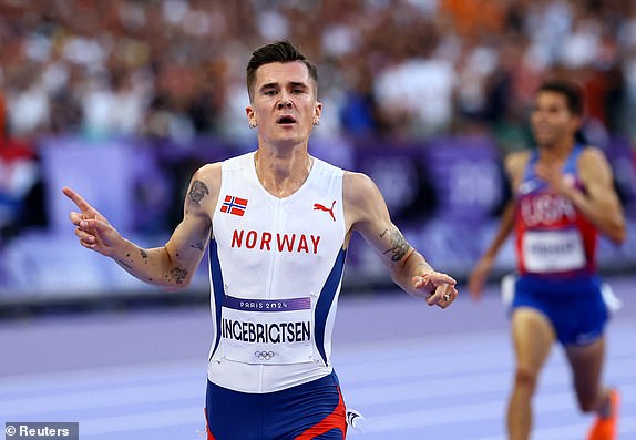 Paris 2024 Olympics - Athletics - Men's 5000m Final - Stade de France, Saint-Denis, France - August 10, 2024.  Jakob Ingebrigtsen of Norway crosses the line to win gold. REUTERS/Kai Pfaffenbach