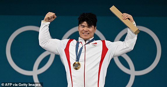 Gold medallist China's Liu Huanhua celebrates on the podium after the men's -102kg weightlifting event during the Paris 2024 Olympic Games at the South Paris Arena in Paris, on August 10, 2024. (Photo by ARUN SANKAR / AFP) (Photo by ARUN SANKAR/AFP via Getty Images)