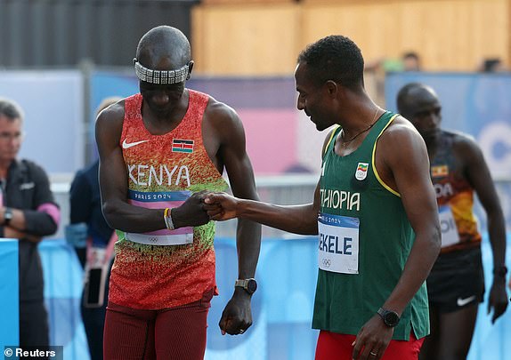 Paris 2024 Olympics - Athletics - Men's Marathon - Paris, France - August 10, 2024. Eliud Kipchoge of Kenya bumps fists with Kenenisa Bekele of Ethiopia before the race. REUTERS/Isabel Infantes