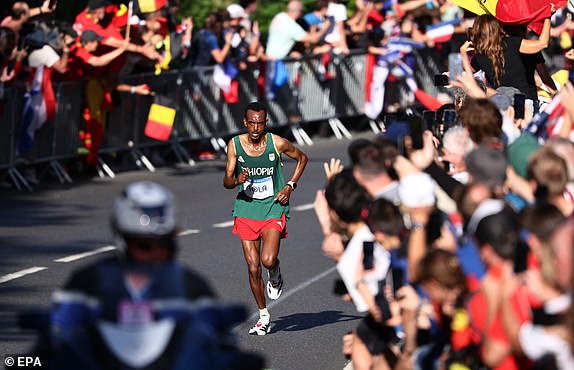 epa11541678 Tamirat Tola of Ethiopia (C) competes during the Men's Marathon event of the Athletics competitions in the Paris 2024 Olympic Games in Paris, France, 10 August 2024.  EPA/ANNA SZILAGYI