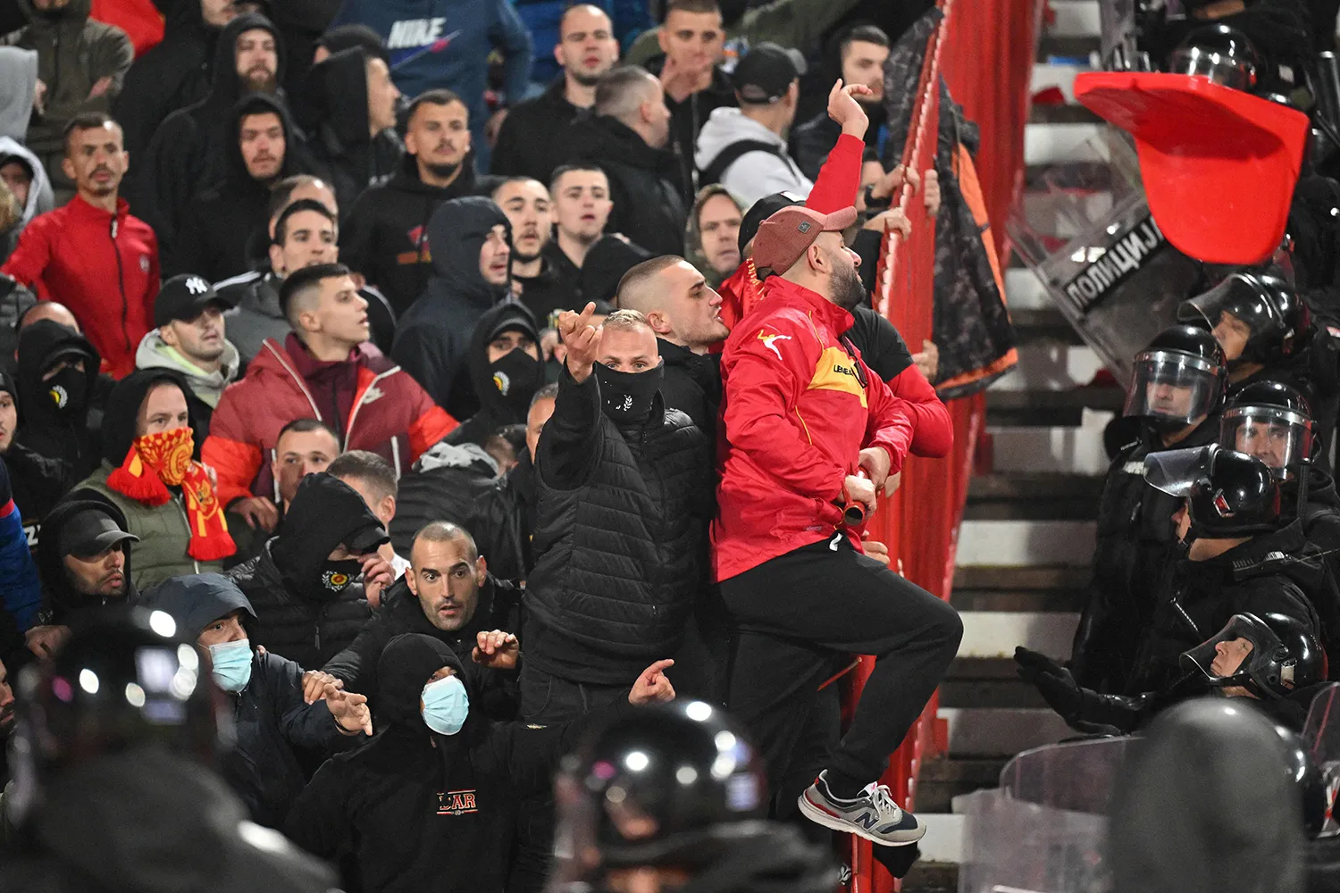 Montenegro's supporters clash with security personnel and riot police during the Euro 2024 qualifying match between Serbia and Montenegro in Belgrade on Oct. 17, 2023.