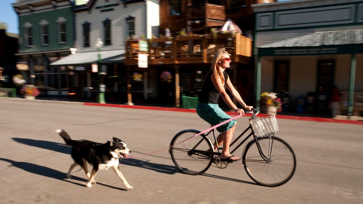 Woman bikes down Elk Avenue in Crested Butte, Colorado