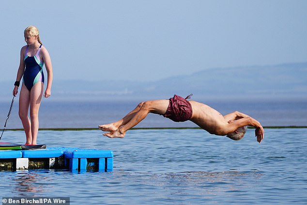 Pictured: People enjoying the warm weather at Clevedon Marine Lake in North Somerset on Monday morning