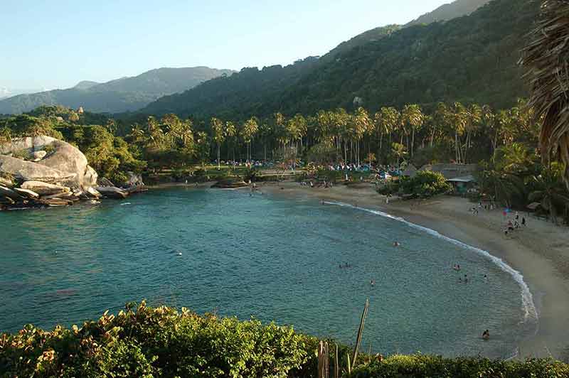 beaches in colombia south America curved beach with palm groves and mountain in the background