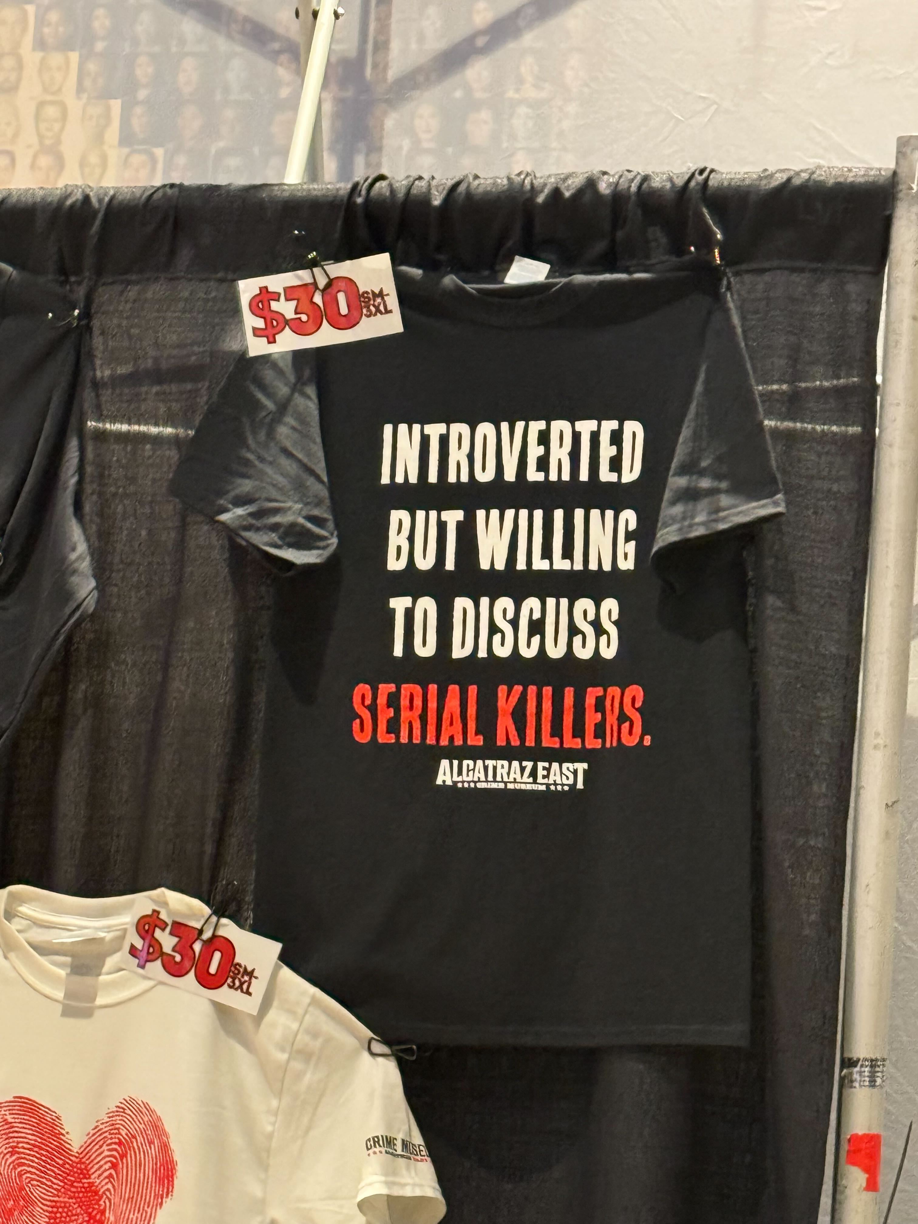 CrimeCon merch for sale, including black T-shirts that say 