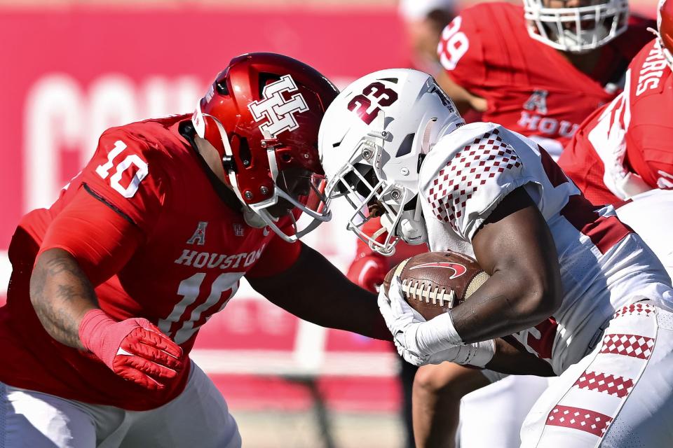 Nov 12, 2022; Houston, Texas, USA; Houston Cougars defensive lineman Chidozie Nwankwo (10) tackles Temple Owls running back Edward Saydee (23) during the first quarter at TDECU Stadium. Mandatory Credit: Maria Lysaker-USA TODAY Sports