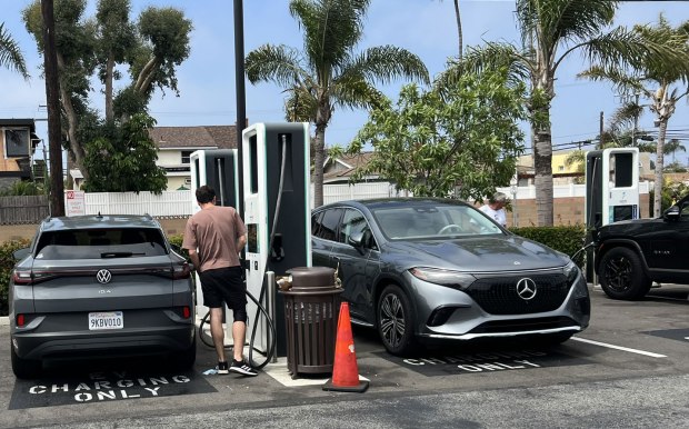 Electric vehicle drivers charge up at a public fast-charging station at the Pavillions shopping center in Seal Beach. Fast chargers like these can get an EV to 80% capacity in under an hour, but cost about $150,000 to $175,000 to install, CBRE's Jim Hurless said. (Photo by Jeff Collins, Orange County Register/SCNG)