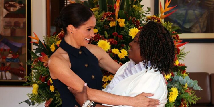 Meghan Markle Arrives in Colombia Wearing a Navy Vest and Trousers