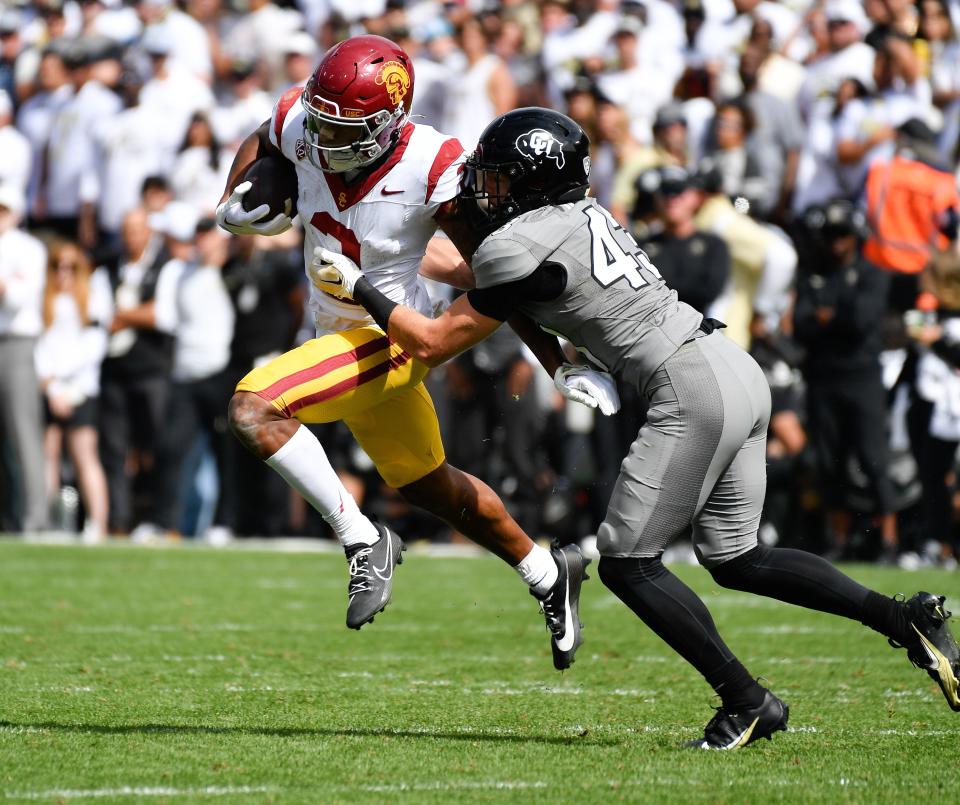 Sep 30, 2023; Boulder, Colorado, USA; Colorado Buffaloes safety Trevor Woods (43) pulls down USC Trojans wide receiver Brenden Rice (2) after a short gain during the third quarter at Folsom Field. Mandatory Credit: John Leyba-USA TODAY Sports