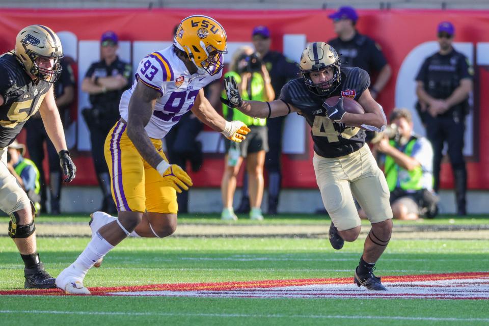 Jan 2, 2023; Orlando, FL, USA; Purdue Boilermakers running back Devin Mockobee (45) carries the ball against LSU Tigers defensive end Quency Wiggins (93) during the second half at Camping World Stadium. Mandatory Credit: Mike Watters-USA TODAY Sports