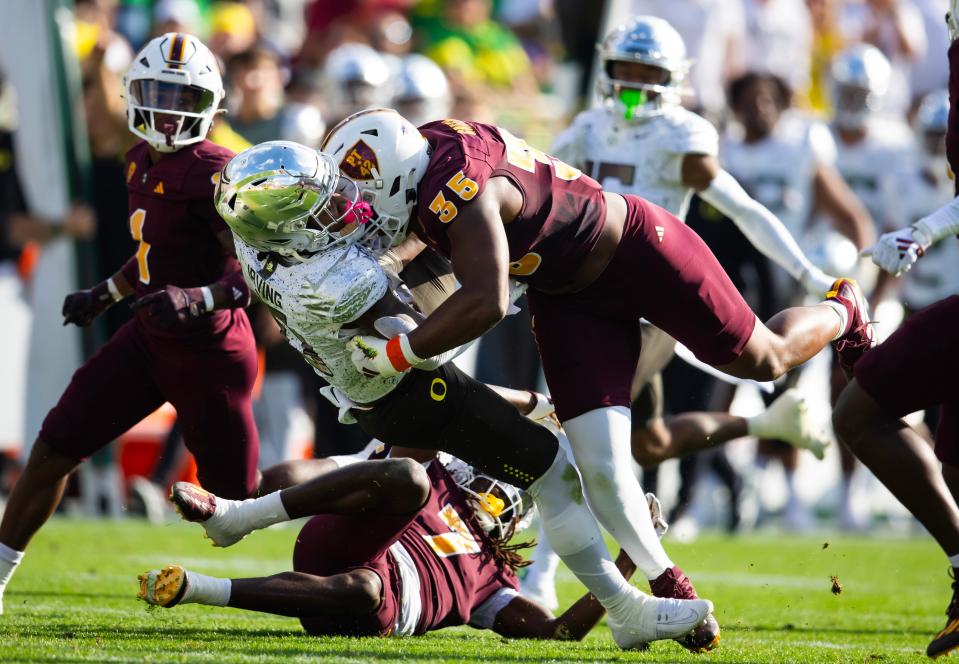 Nov 18, 2023; Tempe, Arizona, USA; Oregon Ducks running back Bucky Irving (0) is tackled by Arizona State Sun Devils defensive lineman B.J. Green II (35) in the first half at Mountain America Stadium. Mandatory Credit: Mark J. Rebilas-USA TODAY Sports