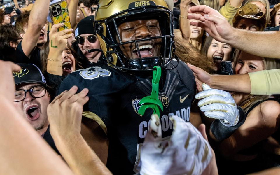 CU football's sophomore defensive end Arden Walker celebrates with students who rushed the field after a thrilling win against CSU in the Rocky Mountain Showdown on Sept. 16, 2023 at Folsom Field in Boulder, Colo.